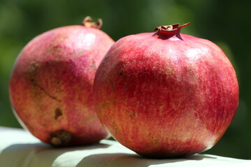 Refreshing view of two healthy, ripe, red pomegranates in daylight