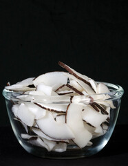 Coconut Cut Pieces in Glass bowl. on Isolated Black Background. Conceptual Photography, 