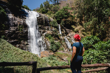 Frau vor Wasserfall in Thailand