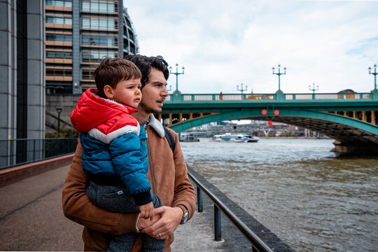 Father and son looking towards the river next to the Southwark Bridge in London
