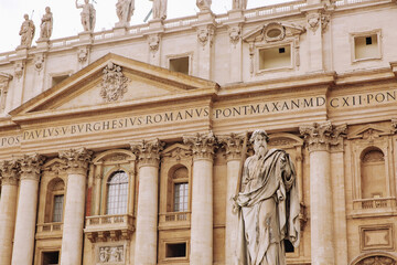 St. Peter, Vatican City. Low angle view of the statue of St. Peter in St. Peter's Square, Vatican City, with the façade of the Basilica in the background.