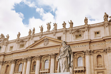 St. Peter, Vatican City. Low angle view of the statue of St. Peter in St. Peter's Square, Vatican City, with the façade of the Basilica in the background.