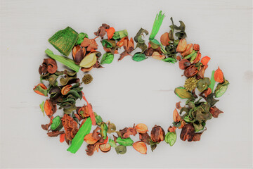Decorative dry leaves scattered in a circular shape on wooden board