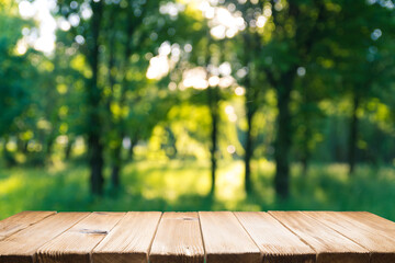 Empty wooden deck table with park bokeh background. - obrazy, fototapety, plakaty
