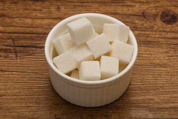 Fototapeta na wymiar Refined white sugar cubs in the bowl