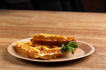 .Viennese waffles on a disposable plate with mint