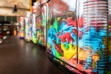 Colorful vintage plastic toys in a glass jar.