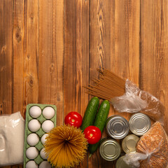 Food delivery during coronavirus quarantine: canned food, cereals. Long-term storage of food and basic necessities close-up on a wooden background. Flat lay