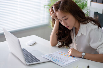 Beautiful Asian business women feel stressed and tired from working in the office.