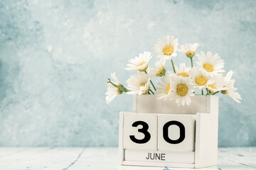 White cube calendar for june decorated with daisy flowers