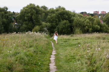 children run away along the path in the park, the concept of summer and childhood, child safety.