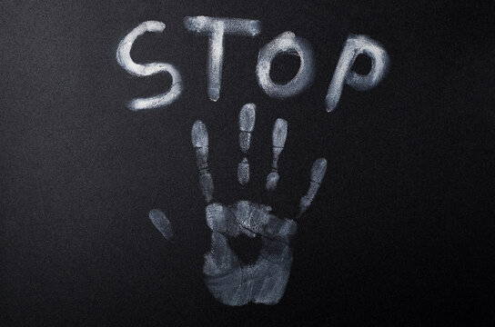 Concept of Stop Violence. White handprint and word Stop on the black banner