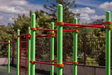 green and red horizontal bars on a playground in the summer

