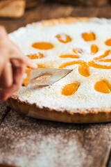 Cutting sweet delicious apricot curd cake pie