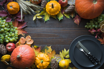 Border of fall harvest, pumpkins, dry leaves, grapes, set for place setting. Thanksgiving Day. View...