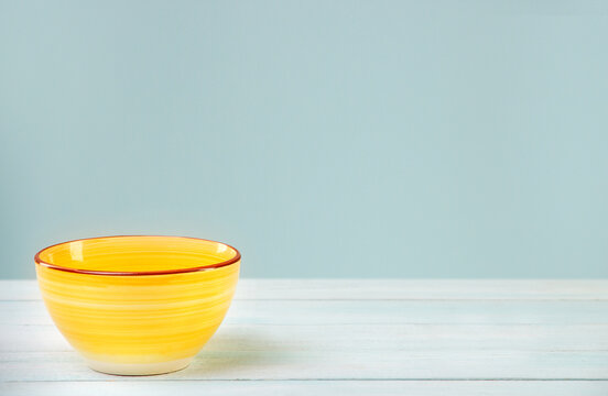 
Ceramic Empty Deep Yellow Bowl On A Wooden Table