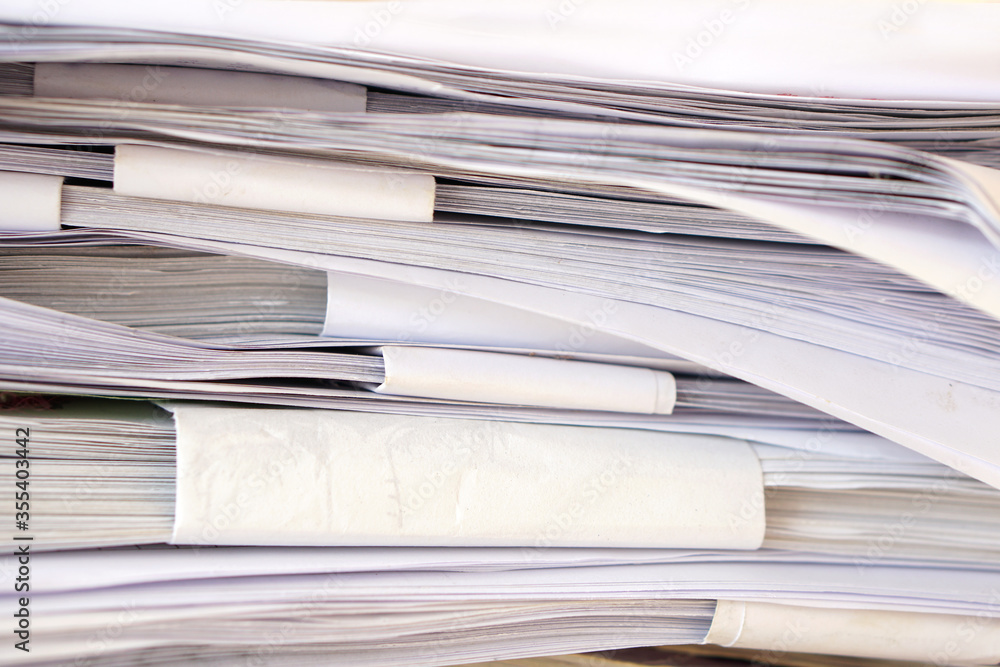 Poster stack of business report paper files on desk