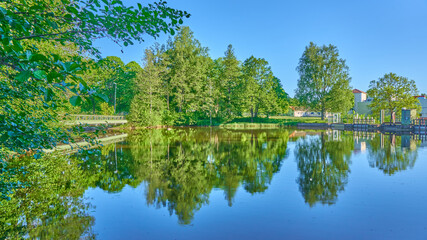 Fototapeta premium The green trees reflected in the water, Spring, Sweden