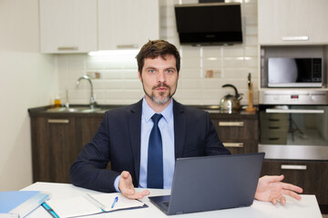 man in a suit works at a computer at home. Business communication concept.
