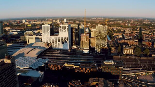Aerial drone tracking shot of central train station and city centre in Utrecht with the modern buildings surrounding it, The Netherlands