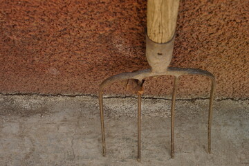 old pitchfork stand on the stone floor, top view, close-up