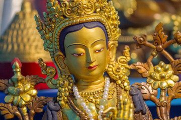 Close up of Golden statue showing buddhist deity Tara at a temple.