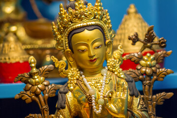 Golden statue showing buddhist deity Tara at a temple. - obrazy, fototapety, plakaty