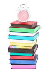 An alarm clock on top of stack of colorful books