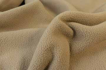 A yellowish brown fluffy short fur fleece fabric look cozy was lying on the floor. © Tawanrat