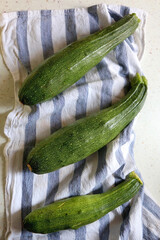 Three homegrown zucchinis on the kitchen counter. Top view.