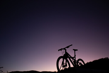 Fototapeta na wymiar Silhouette of Mountain Bike, Dirt bike on the car roof rack in the countryside at the sunset,Bicycles built for traveling on dirt road.