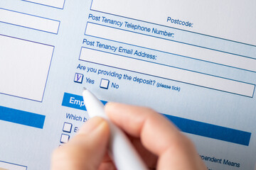 Woman filling contract, tick yes and agrees to leave a deposit. Close up. Selective focus.