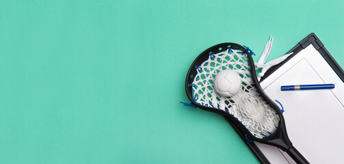 Lacrosse stick, ball and tactical board with marker on green background. Sport coach concept