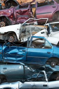 Stacked old cars on a junk yard, vertical image of car wrecks 