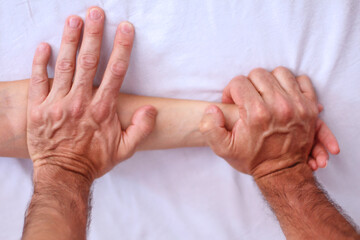 Fototapeta premium Shiatsu massage. Close up of massagers hands working on patients hand and forearm.