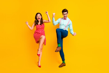 Full length photo attractive lady handsome guy couple win lottery scream astonished raise fists legs wear red dotted dress shirt bowtie retro clothes isolated yellow color background