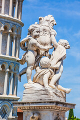 Fototapeta premium Cupid statue and the Leaning Tower of Pisa. Italy