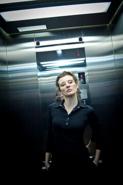 Portrait Woman, Businesswoman, In Office Dark Clothes, In A Dark And Cramped Space, Elevator.