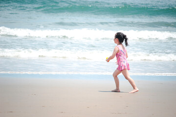 Little cute kid girl  having fun on sandy summer with blue sea, happy childhood friend running and  playing on tropical beach