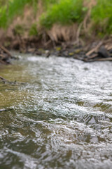 Close-up of rushing water, photo of wave texture and background. Waves of a small stream. Siberia of beauty.