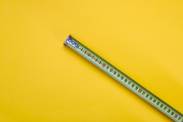 Measuring tape on yellow background.