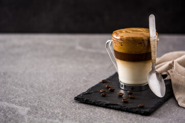 Creamy iced dalgona coffee on gray stone  background. Copy space	
