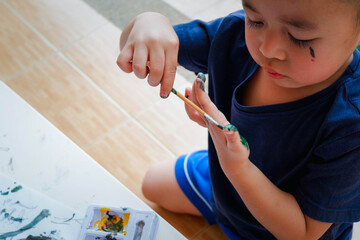 Funny little boy with painted hand