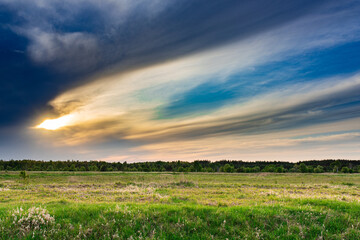 Słońce przebijające się przez chmury nad łąką © Zentofoto
