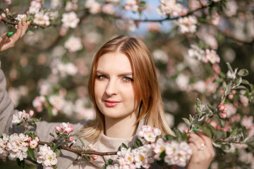 Fototapeta premium Young girl in a blooming apple orchard