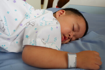 The sick boy was sleeping in a hospital bed. Boy is sick with Respiratory Syncytial Virus.