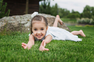 Naklejka na ściany i meble little girl lying on the grass