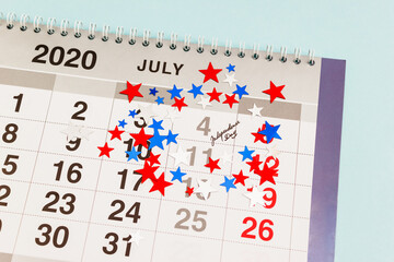 Close up of July 4th date on calendar decorated with national colors confetti. US Independence Day...