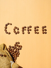 coffee beans lettering and craft eco 
sackcloth bag on beige background. vertical, template