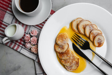 Trendy homemade Breakfast with mini pancakes and orange sauce on a white table. The view from the top. Side view. Space for text